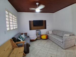 a living room with a couch and a flat screen tv at Recanto do Sossego in Águas de Lindoia