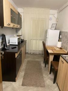 eine Küche mit Tisch und Kühlschrank in der Unterkunft Lemora Apartments 2 in Focşani + 3 Fotos