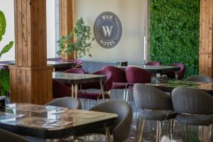 een restaurant met tafels en stoelen en een bord aan de muur bij Wan Hotel in Duhok