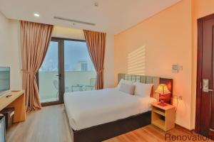 ein Schlafzimmer mit einem weißen Bett und einem Fernseher in der Unterkunft Dylan Hotel Danang in Đà Nẵng + 60 Fotos