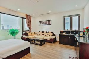 ein Hotelzimmer mit einem Bett und einem Wohnzimmer in der Unterkunft Dylan Hotel Danang in Đà Nẵng