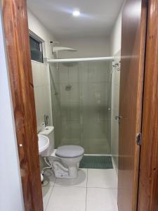 ein Badezimmer mit Toilette und Glasdusche in der Unterkunft Cabo de Santo Agostinho Apartmento in Cabo de Santo Agostinho + 14 Fotos