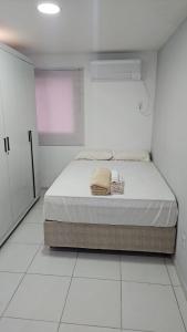 ein weißes Schlafzimmer mit einem Bett in einem Zimmer in der Unterkunft Cabo de Santo Agostinho Apartmento in Cabo de Santo Agostinho