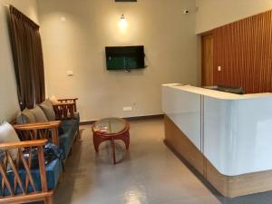 a living room with a couch and a tv on the wall at Skyleaf Resort in Meenangadi +7 photos