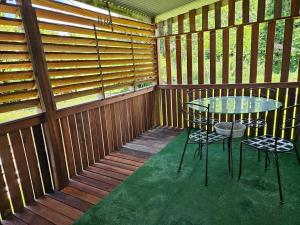 a room with a table and chairs in a wooden cabin at Célia in Matoury