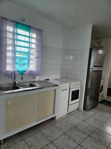 a kitchen with a sink and a refrigerator at Célia in Matoury +2 photos