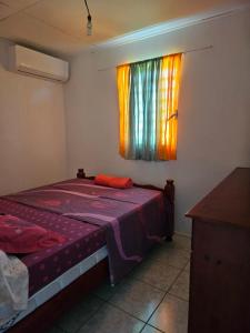 a bedroom with a bed and a window at Célia in Matoury