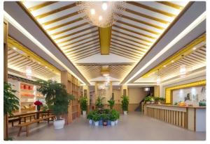a lobby with tables and potted plants in a building at Zhangjiajie Oxygen Lodge in Zhangjiajie