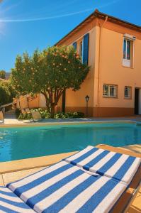 Studio de la Villa Thérèse, Piscine & Jardin في سان لوران دو فار: حوض سباحة عليه منشفة زرقاء وبيضاء