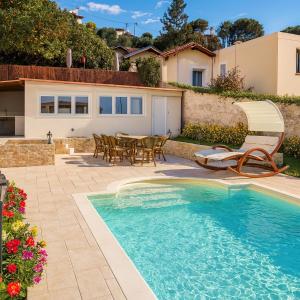 Studio de la Villa Thérèse, Piscine & Jardin في سان لوران دو فار: منزل به مسبح وطاولة وكراسي