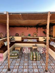 ein Zimmer mit Sofas und Tischen in einem Haus in der Unterkunft Zeri Surf Camp in Tiguemmi nʼAït Bihi