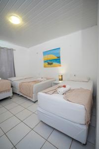 a room with two beds and a painting on the wall at Pousada Hippopotamus Jeri in Jericoacoara