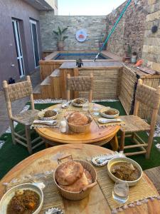 einen Tisch mit Schüsseln Essen auf einer Terrasse in der Unterkunft Zeri Surf Camp in Tiguemmi nʼAït Bihi