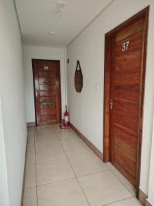 a hallway with two wooden doors and a tile floor at Hotel Val-de-Cans Aeroporto in Belém
