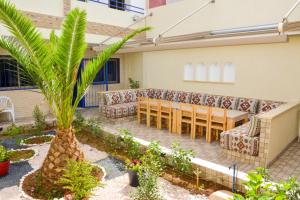 ミルレフトにあるRiad Dar Fayçal - 6 Chambresのヤシの木のあるパティオ(テーブル、椅子付)