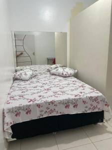 een slaapkamer met een bed met een bloemenbed en kussens bij Fenix Pousada in Manaus