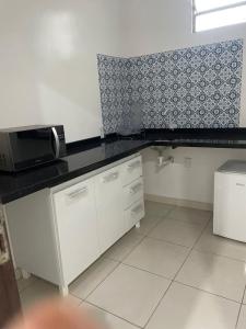 een keuken met een zwart aanrecht en een magnetron bij Fenix Pousada in Manaus