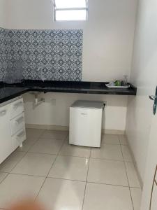 een kleine keuken met een aanrecht en een kleine koelkast bij Fenix Pousada in Manaus