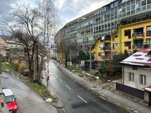 una strada vuota di fronte a un alto edificio giallo di Orient Apartment Old Town a Sarajevo