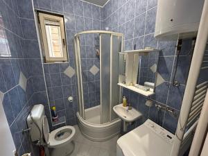un bagno piastrellato blu con un water e un lavandino di Orient Apartment Old Town a Sarajevo Altre 21 foto