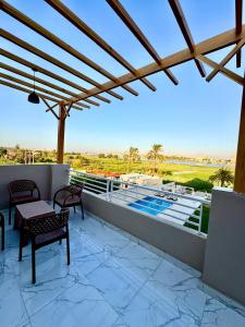 a patio with a table and chairs on a balcony at Royal Nile Villas - Luxury Nile View Apartment 2 in Luxor