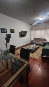 Ruta Amazônica Hostel في بيليم: غرفة معيشة بها طاولة وأريكة +7 صور