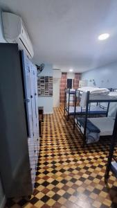 Ruta Amazônica Hostel في بيليم: غرفة بها عدة أسرة بطابقين وأرضية مربعة