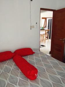 a bedroom with a bed with red pillows on it at Homestay Tata in Bugisan