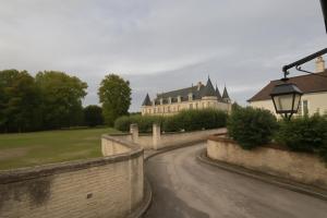 a road leading to a castle with a building at Le gîte de l’espérance in Arc-en-Barrois