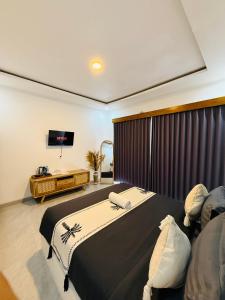 a bedroom with a large bed and a television at Talvista Kintamani Villa in Kintamani +14 photos