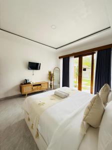 a white bedroom with a large bed and a tv at Talvista Kintamani Villa in Kintamani
