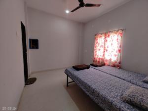 TuljapurにあるAadishkti nivas family Roomsのベッドと天井扇風機のある寝室 +11枚の写真
