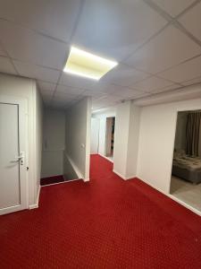 an empty room with a red carpet and a hallway at Apartament cu 5 camere in Craiova