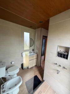 ein Badezimmer mit zwei Toiletten und einem Waschbecken in der Unterkunft Finca Ocho Cerros in Tornquist