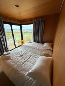 ein paar Betten in einem Zimmer mit Fenster in der Unterkunft Finca Ocho Cerros in Tornquist