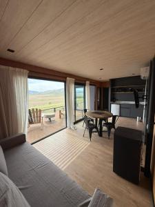 Blick auf ein Wohnzimmer mit Tisch und Stühlen in der Unterkunft Finca Ocho Cerros in Tornquist