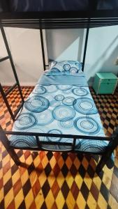 Ruta Amazônica Hostel في بيليم: سرير مغطى بغطاء أزرق في غرفة