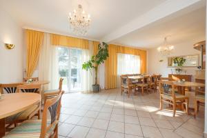 Casa Stefano في فيينا: غرفة طعام مع طاولات وكراسي وثريا