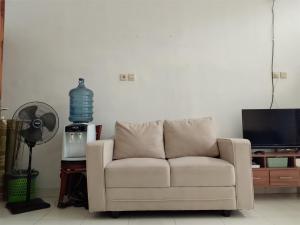 a living room with a white couch and a television at Homestay Tata in Bugisan