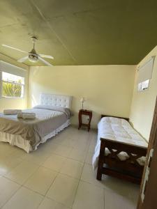 阿祖尔海Princesas Del Mar a 4 cuadras del mar的一间卧室，里面有两张床和一张长凳。