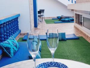 two wine glasses sitting on a table in a room at MJ twin blue door imsouane in Imsouane