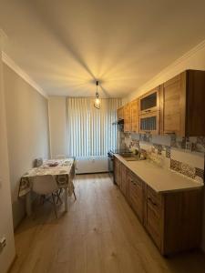 a kitchen with wooden cabinets and a table in it at Apartament 2 camere ultracentral in Craiova +3 photos