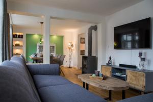 een woonkamer met een blauwe bank en een tafel bij Haus Wunschlos Kirchstraße in Monschau