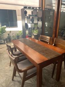 ein Esstisch aus Holz mit Stühlen und einem Regal in der Unterkunft Residencia Helen in Katungal