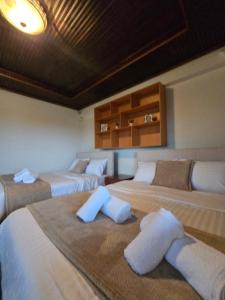 una stanza con tre letti con asciugamani sopra di Αρχοντικό Παπανικολάου a Lygariá Altre 63 foto