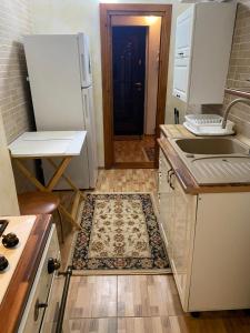 een keuken met een spoelbak en een koelkast bij Lemora Apartments 3 in Văleni