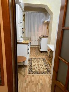 een kleine keuken met witte apparatuur en een tafel bij Lemora Apartments 3 in Văleni