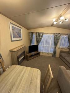Kinmel Bay3 bedroom Lyons Oakfield Towyn pets welcome的带沙发、电视和桌子的客厅