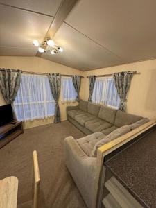 Kinmel Bay3 bedroom Lyons Oakfield Towyn pets welcome的客厅里有一张沙发和一台电视