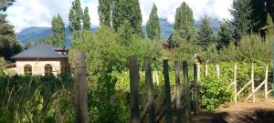 una valla delante de una casa en un viñedo en Finca Fraschetti, en El Bolsón